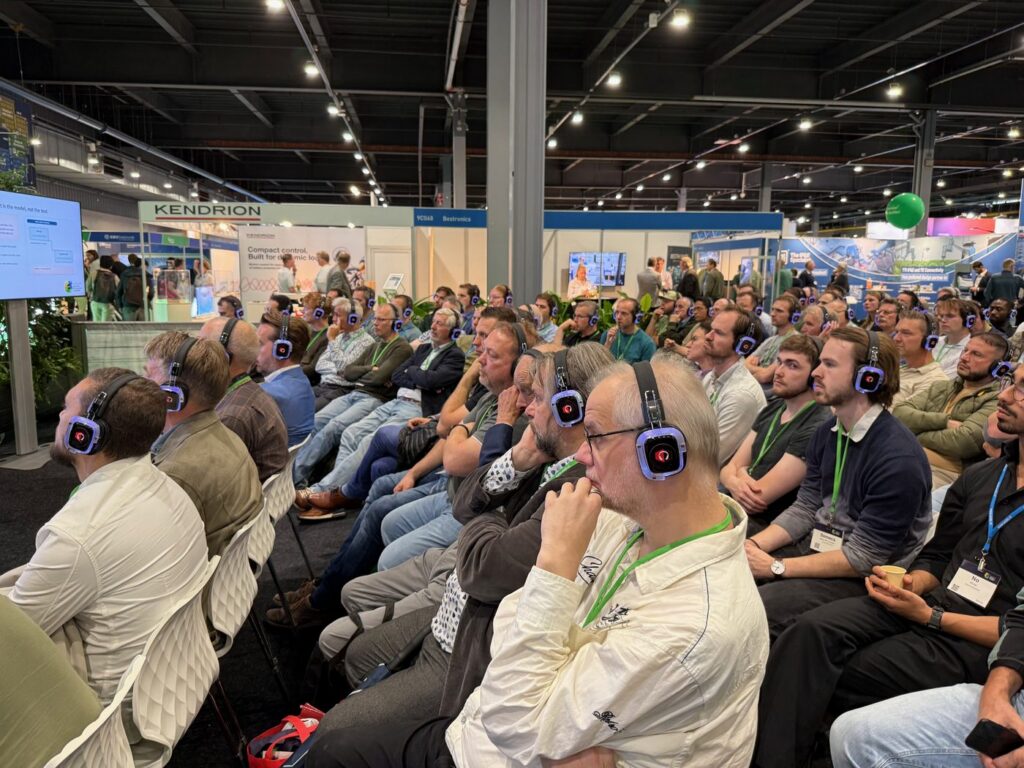 Volle zaal met koptelefoons tijdens de sessie op WoTS 2026